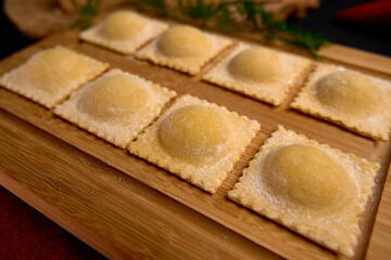 Delicious Freshly Made Ravioli Displayed on a Wooden Board Ready for Cooking and Serving, Showcasing Their Unique Round Shape and Delicate Texture