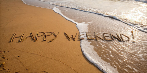Happy Weekend! written in sand on a sunlit beach with waves