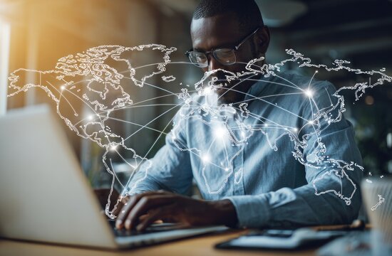 Businessman working on laptop with world map overlay