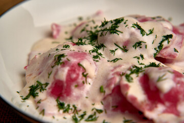 Deliciously Prepared Dumplings Drenched in Creamy Sauce and Topped with Fresh Herbs for an Irresistible Culinary Delight