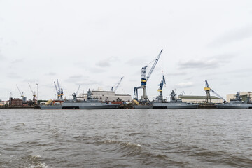 Port with cranes and war ships in Hamburg Germany