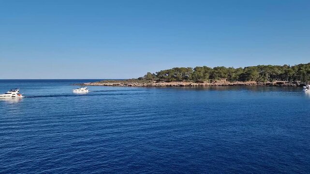 Wonderful Paradise bay of Camyuva, Kemer, Turkey. Scenery sea view to the coast with boats on the blue water. Summertime holiday seascape