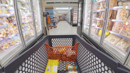 POV from shopping cart in supermarket frozen aisle, following a woman and two kids. Shelves filled with frozen food products. Family grocery shopping in bright modern store - Powered by Adobe
