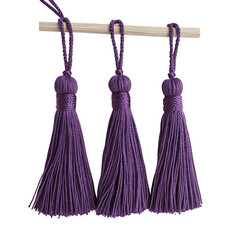 Purple tassels for crafts and home decor projects hanging together in an elegant arrangement