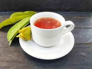 Soursop leaf boiled water in glass with wooden table background. Healthy drink lifestyle