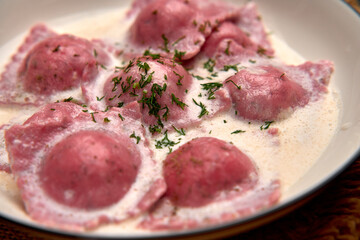 Deliciously Crafted Pink Ravioli Served in Creamy Sauce Garnished with Fresh Herbs for a Flavorful Culinary Experience