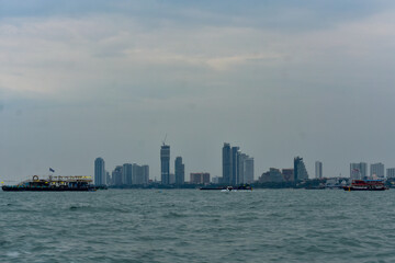 Pattaya City skyline from the sea, featuring towering buildings and a communication tower.