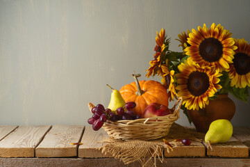 Autumn background with sunflowers, grapes, pumpkin and pears on wooden table. Kitchen mock up for design and product display