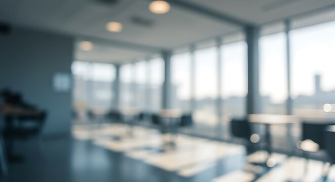 Blurry interior of a modern office space with large windows and tables and chairs inside the room
