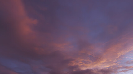Dramatic sunrise with gradient orange and purple clouds, creating a panoramic abstract sky view.