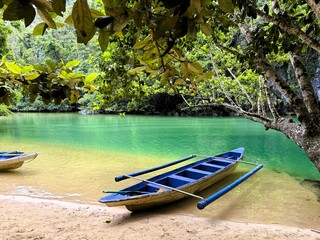 Canoe Resting on the Sandy Beach by a Tropical River