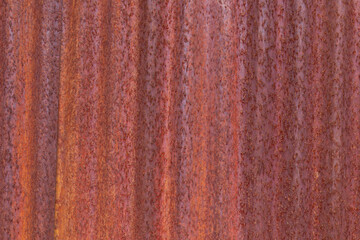 Front-facing view of heavily rusted corrugated metal sheet, reddish tones, clean composition as texture or background