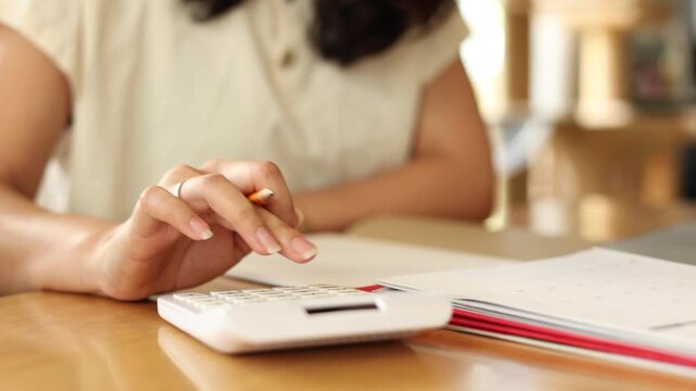 slow motion scene accountant woman press on calculator to check about profit or budget and debt of company at office desk for business financial concept - Powered by Adobe