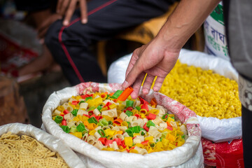 A man holds dry pasta made from flour in the market