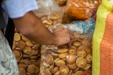 A man holds a dry biscuit in a sack in the market