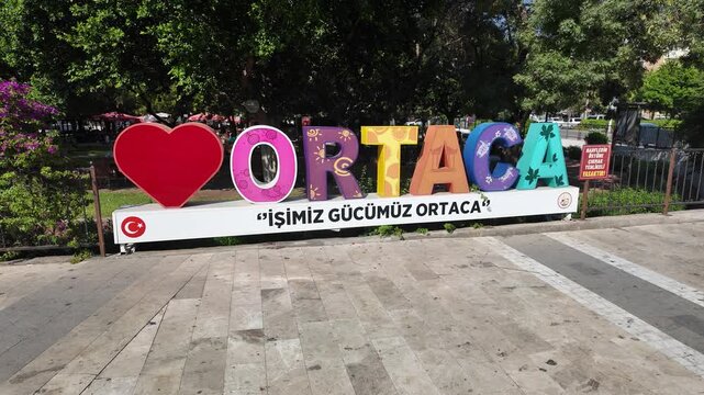Colorful Ortaca sign with Turkish text and heart symbol in public park setting in Ortaca, Mugla, Turkey, welcoming visitors to Ortaca town