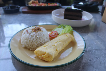 Delicious Asian Breakfast with Omelette, Steamed Rice, and Fresh Vegetables