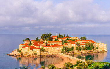Obraz premium panoramic landscape of sea island sunrise or sunset with beautiful orange roofs and buildings, sea gulf water and scrnic colorful morning cloudy sky on background