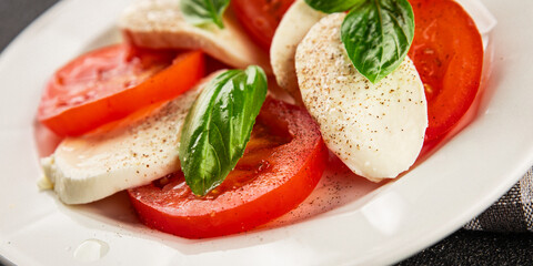 Caprese salad mozzarella and tomato, basil fresh delicious gourmet food background on the table rustic food top view copy space keto and paleo diet vegan and vegan food