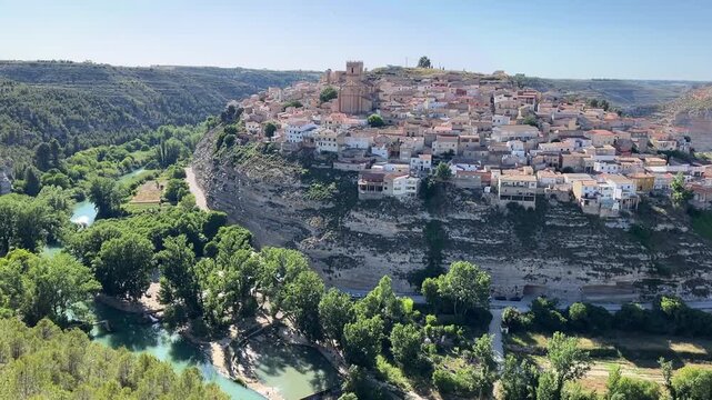 Panoramic view of Jorquera on the hill above blue river. Charming Spanish village built into the cliffs of a dramatic canyon, Castilla-La Mancha, Spain. 25 May 2025