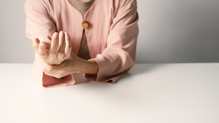 Asian business woman massaging wrist in pain Caused by working on a computer keyboard for a long time, wrist pain and numbness in the wrist. While working at the office