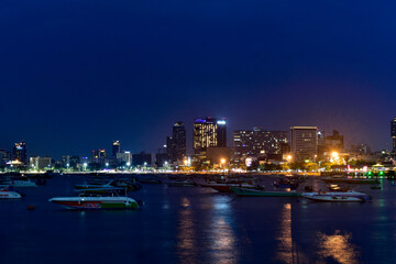 Fototapeta premium Pattaya city skyline at night with boats on the bay.