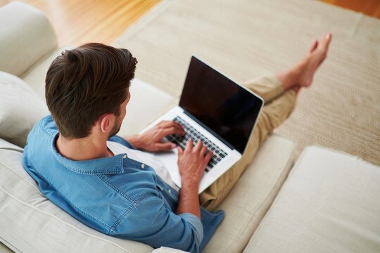 Man working on laptop at home on couch remote work lifestyle and home office concept