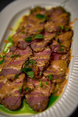 Succulent Slices of Duck Breast Topped with Savory Sauce and Fresh Microgreens, Perfectly Plated for a Gourmet Dining Experience