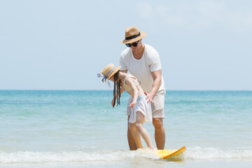 Caucasian family including father, mother, and daughter are delightful enjoy with beach vacation...