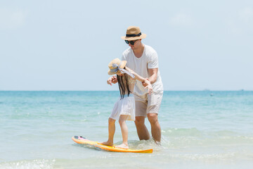 Caucasian family including father, mother, and daughter are delightful enjoy with beach vacation...