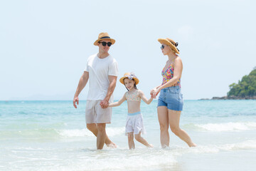 Caucasian family including father, mother, and daughter are delightful enjoy with beach vacation...