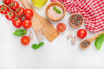 Assorted cooking ingredients with tomatoes, spices, and kitchen tools on white background with red cloth. top view. copy space. © Надія Коваль