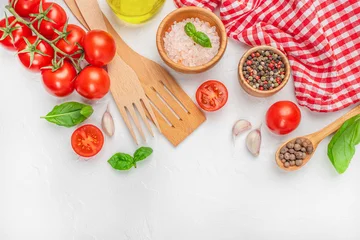 Assorted cooking ingredients with tomatoes, spices, and kitchen tools on white background with red cloth. top view. copy space. © Надія Коваль