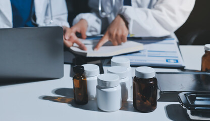 Male and female doctors are having a meeting in a hospital room.