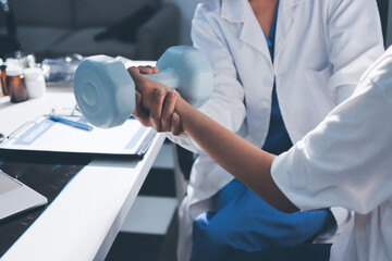 Unrecognizable uses blue hand weight during physical therapy session