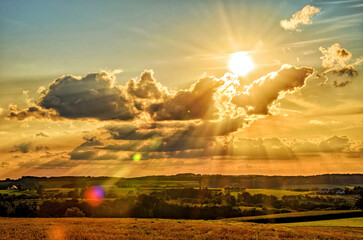 Sonne bricht strahlend durch bizarre Wolken und taucht die Landschaft der Fränkischen Schweiz in...