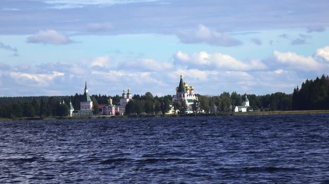 View from the water at Valdai Iversky Svyatoozersky Virgin Monastery for Men. Selvitsky Island, Valdai Lake. View of the Valdai Iversky Bogoroditsky svyatoozersky monastery. Sunny June day,
