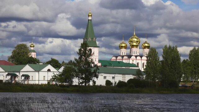 View from the water at Valdai Iversky Svyatoozersky Virgin Monastery for Men. Selvitsky Island, Valdai Lake. View of the Valdai Iversky Bogoroditsky svyatoozersky monastery. Sunny June day,