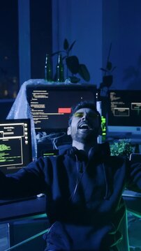 A man in a tech workspace focuses on a glowing screen, analyzing data