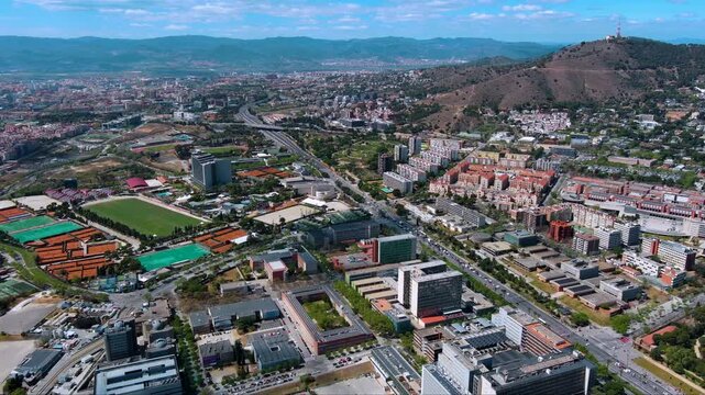 Wide drone view over Vall d Hebron sports complex, Ronda de Dalt and Collserola hills in Barcelona. Clear sunny cityscape for travel, sport and infrastructure stories.