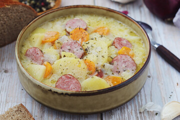 A bowl with traditional German potato soup with sausages
