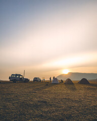 Silhouette of cars and tents during a sunrise on the hills in Koraput, Odisha, India in November 2024....