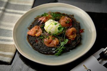 A Gourmet Dish Featuring Delicate Salmon Curled on a Bed of Charcoal Black Rice, Topped with Creamy Burrata and Garnished with Fresh Microgreens