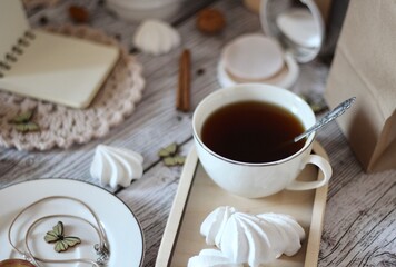 Cup of coffee, meringues, notepad diary and different woman things handmade art decor on wooden background table cozy photo 