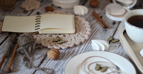 Knitting process, needles, cup of tea and different objects on the table beautiful photo