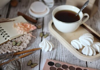 Cup of coffee, meringues, notepad diary and different woman things handmade art decor on wooden background table cozy photo 
