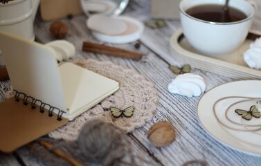 Cup of coffee, meringues, notepad diary and different woman things handmade art decor on wooden background table cozy photo