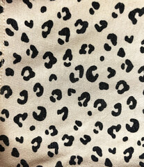 Seamless leopard print fabric with black irregular spots on a beige background. Perfect for fashion, textile design, home decor, accessories, and creative projects with a wild and stylish touch.