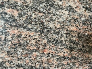 Marble Tile texture closeup as an abstract background. Natural Honed stone slab. Details of matte ceramic wall or floor. Gray surface with satin finish and a pattern of random irregular white spots.