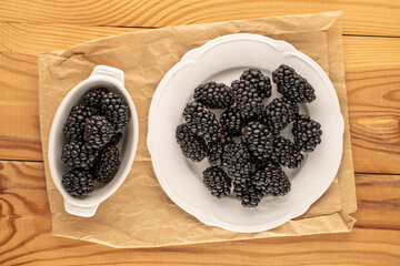 Sweet ripe blackberries on a wooden table, close-up, top view.